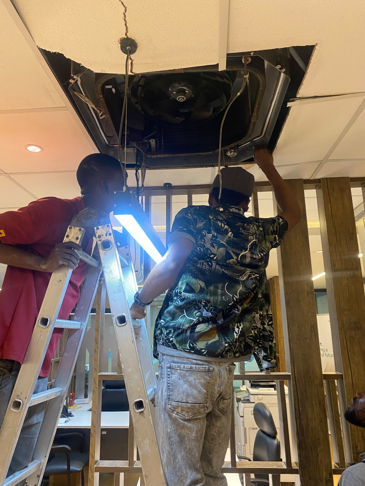 GEIYKE technicians installing a ceiling-mounted HVAC unit
